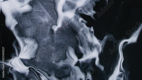 Ink spatter. White blob. Wide enamel stream spreads intricately over dark uneven surface. Art fluid illuminates abstract background.