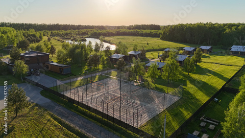Beautiful lakeside retreat featuring modern cabins and sports facilities surrounded by nature at sunset
