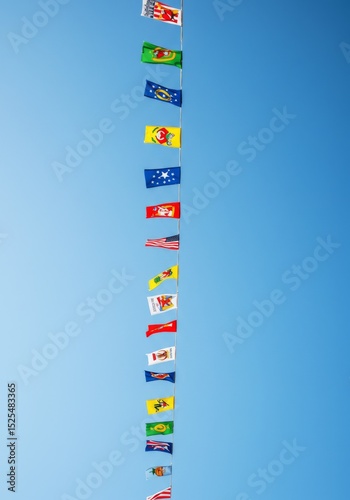 Colorful Flags Hanging Against A Clear Blue Sky