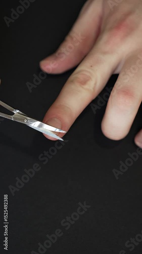 Man trimming his own fingernails with scissors, close-up, 4K