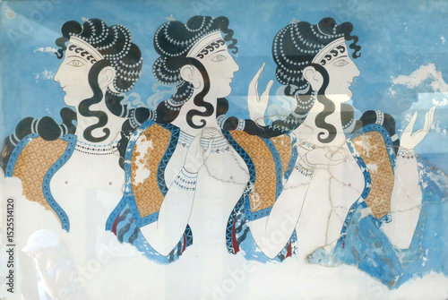 Framed minoan fresco showing three elegant women wearing jewelry and traditional clothing, displayed on a wall