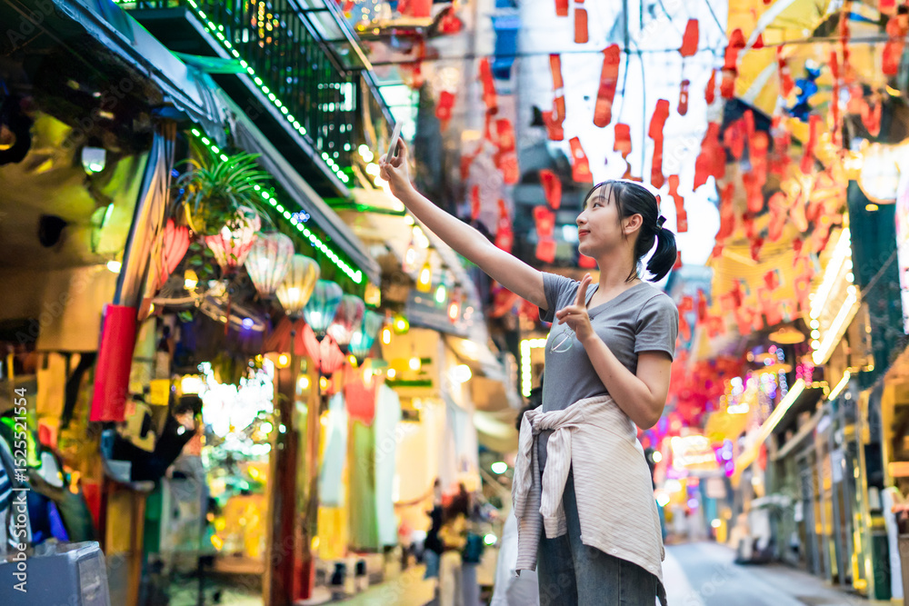Αυτοκόλλητο Woman enjoying local culture while exploring vibrant alley filled with lanterns