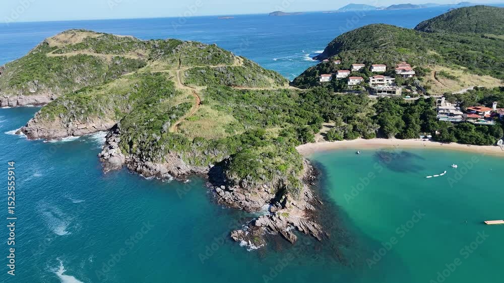 Imagem aérea de drone da Praia da Ferradura, em Armação dos Búzios, Rio de Janeiro, Brasil. Uma enseada de águas calmas, cercada por vegetação e casas de alto padrão, ideal para turismo e náuticos