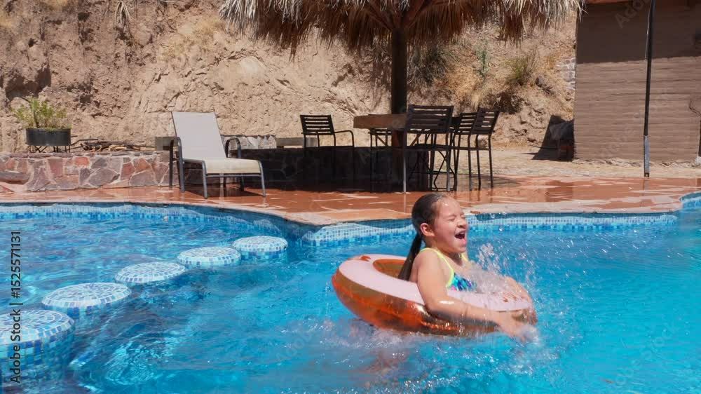 una niña pequeña con un inflable y traje de baño saltando a la alberca feliz y disfrutando de unas vacaciones de verano saltando en el agua fria en la naturaleza