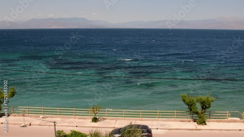 Experience breathtaking Greek coast landscape in Gulf of Corinth, Greece. Stunning turquoise waters meet dramatic cliffs under a clear sky, ideal for travel and relaxation.