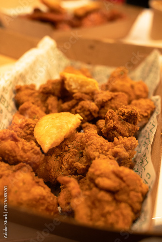 Korean deep dried chicken in paper brown take out box.