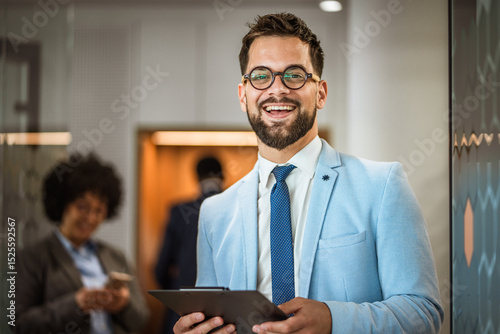 Portrait of a well-dressed caucasian businessman stand with clipboard