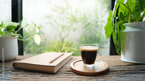 Coffee and brown notebook on rustic wood table by the window