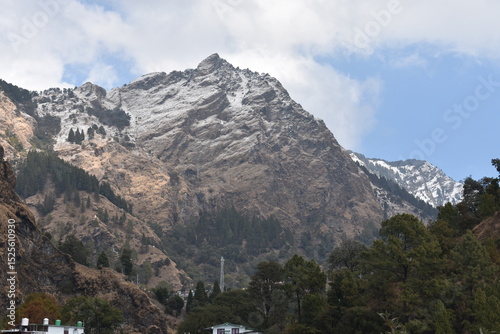 Canvas Print Snow-capped mountains with green trees under a bright sky near Nainital