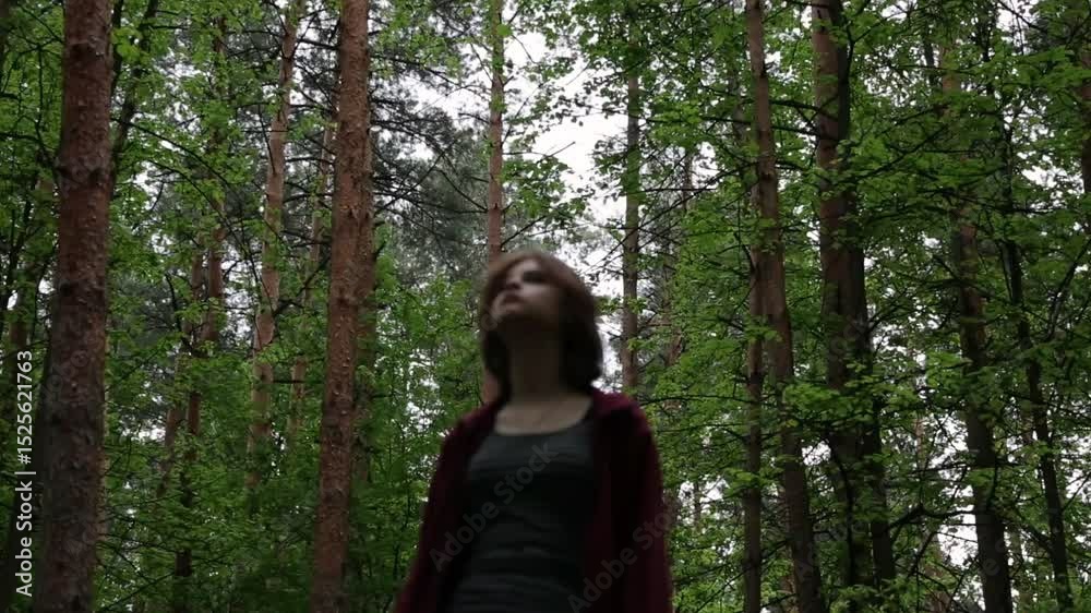 Beauty face young woman looking up on a green pine trees in the forest on sun spring weather. Girl walking in woods, eyes look above in fashion clothes and breath fresh air. Closeup emotion portrait Beauty face young woman looking up on a green pine trees in the forest on sun spring weather. Girl walking in woods, eyes look above in fashion clothes and breath fresh air. Closeup emotion portrait