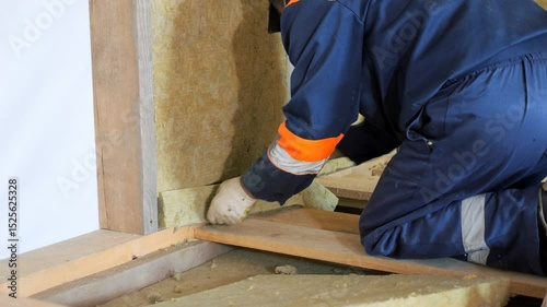Insulation of a frame house with mineral wool. Cutting, fitting, laying insulation. Construction works.