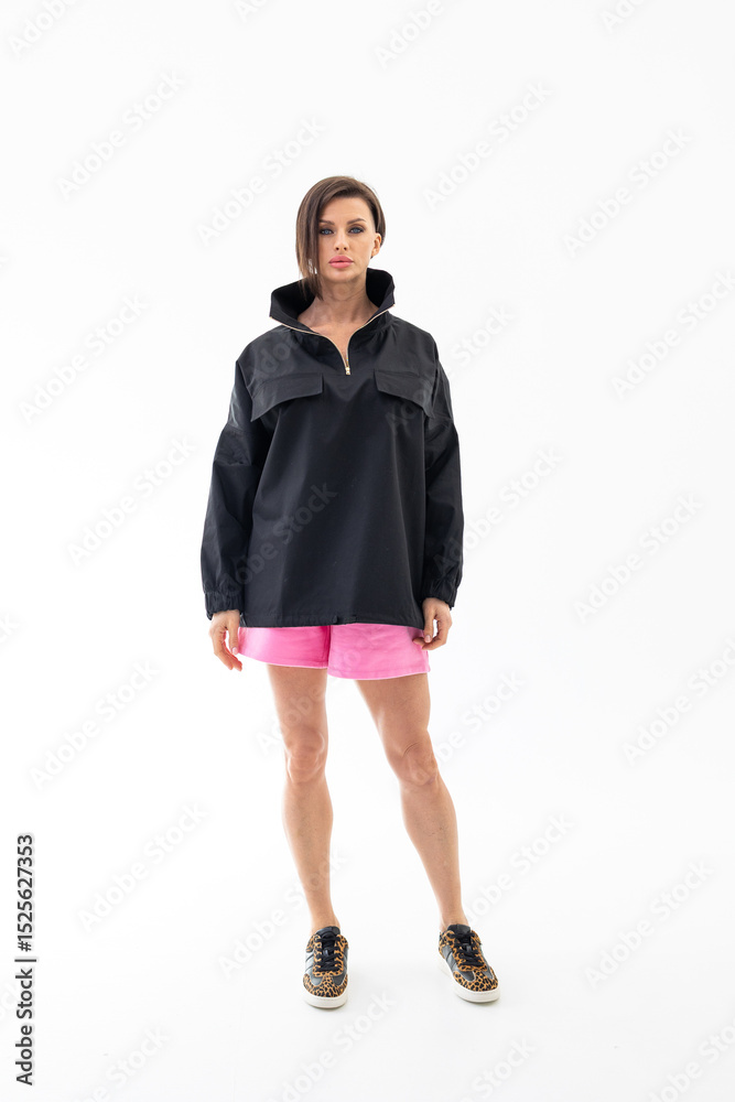 Elegant woman in black windbreaker jacket and pink shorts on light background. Fashionable female style. Studio photography. Vertical photo. High quality photo Elegant woman in black windbreaker jacket and pink shorts on light background. Fashionable female style. Studio photography. Vertical photo. High quality photo
