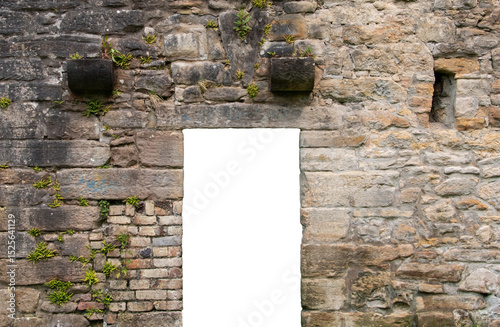 A doorway with a transparent background in an old brick and stone wall in the ruins of a mill, with some plants growing out of the wall.