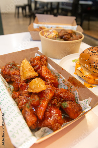 Korean deep dried spicy red chicken sauce in a paper takeaway box.