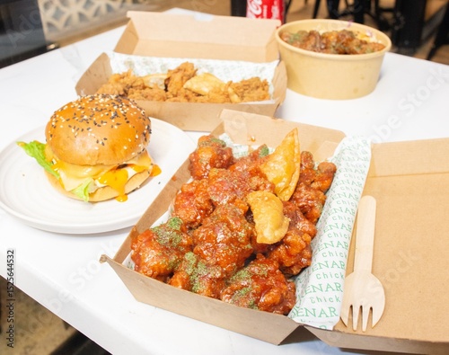 Korean deep dried spicy red chicken sauce in a paper takeaway box.