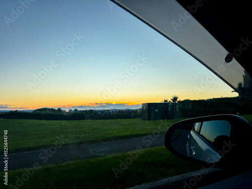 Driving through highway on the coastline at sunset in Auckland, New Zealand.