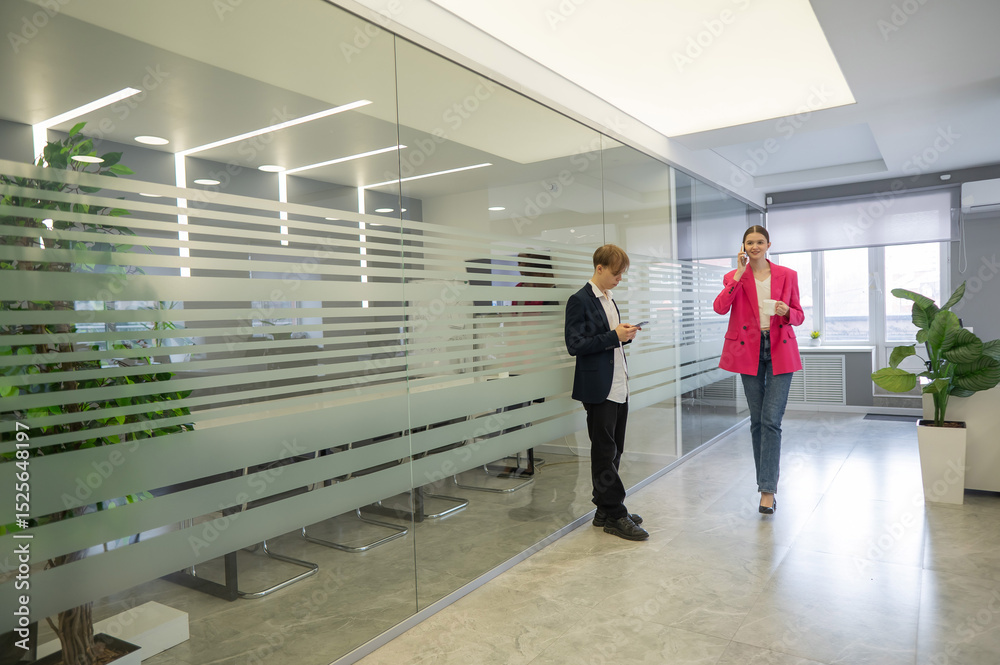 Obraz premium Colleagues use smartphones during breaks at work. 