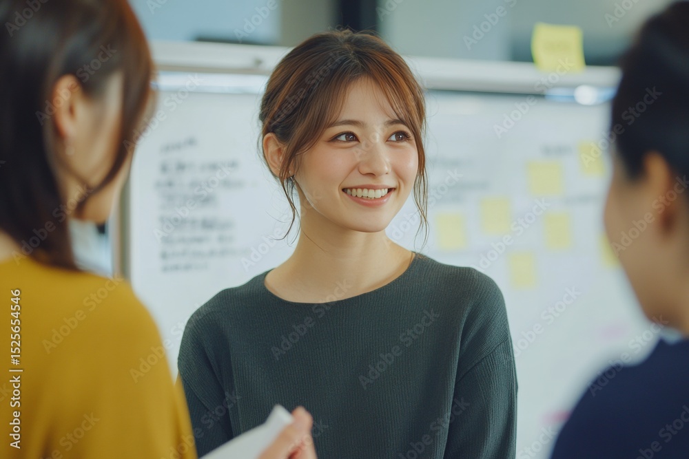 Fototapeta premium Female businesswoman smiling warmly, engaging in a meeting with colleagues.
