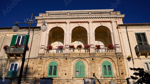 Neoclassical facade of Palazzo Gagliardi with flowers on the balcony in Vibo Valentia, Calabria, Italy