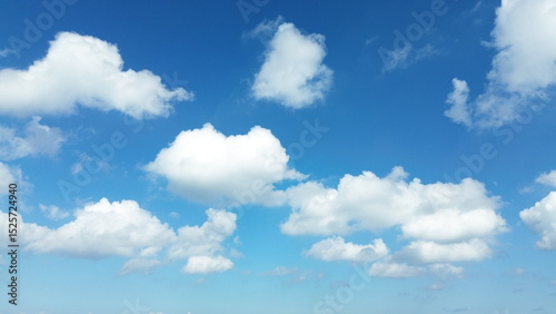 Sun shining through the puffy clouds. Sky view. Beautiful sunny sky. Background with clouds on blue sky. Clouds on blue sky.