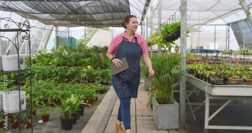 Wallpaper Mural Smiling woman in greenhouse holding tablet, checking plants and enjoying work Torontodigital.ca