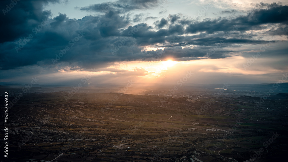 Obraz premium Aerial Panorama of Cappadocia at Sunset with Sunbeams Through Clouds