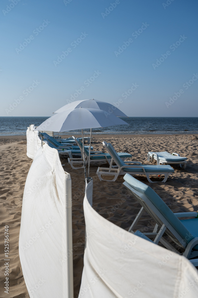 Fototapeta premium White sandy beach in cosy seaside holiday village on North Sea, built in belle epoque style in Flanders, De Haan or Le Coq sur Mer, Belgium