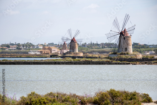 Sea saltworks, salt wind mills and pans, manually extracting high-quality salt, near Marsala and Trapani, Sicily, Italy