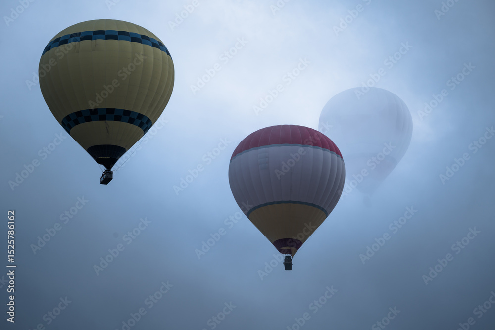 Fototapeta premium Hot Air Balloons Flying Over Cloudy Cappadocia, Turkey