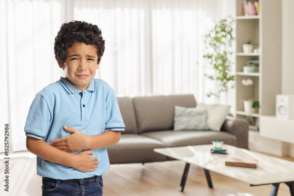 Fototapeta premium Kid with tummy ache in a living room