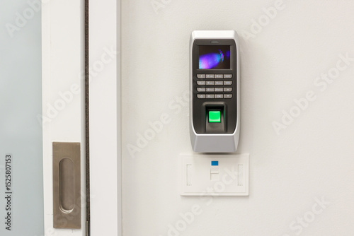 Fingers print scanner machine on wall at front door.

