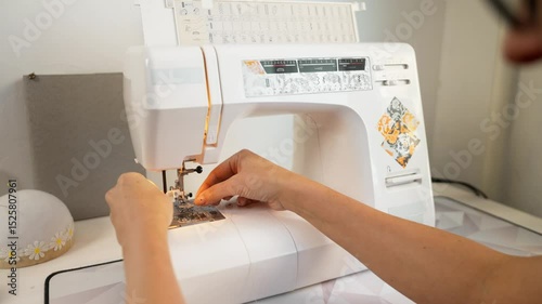 Seamstress adjusts thread tension and needle position on sewing machine, preparing for flawless stitching. Precision in every detail guarantees high-quality fashion pieces.