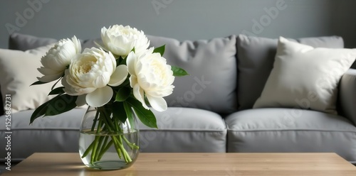 Fototapeta Naklejka Na Ścianę i Meble -  White peonies in vase on coffee table, grey sofa background, beautiful, fresh flowers