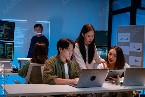 Fototapeta kuchenna Asian software engineer or programmer team working late in development office,problem solving or algorithm of ai assistant helping for work.software developer,digital technology security concept