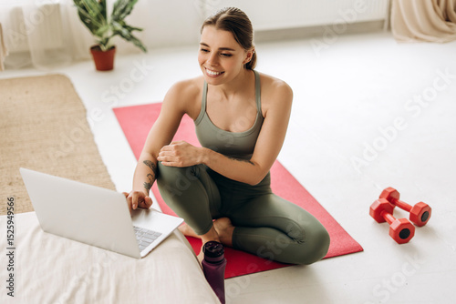 Принти на полотні Fitness instructor preparing online lesson using laptop at home