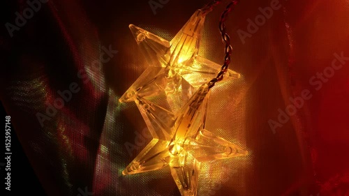 Christmas garland with glittering iridescent fabric.Warm light of garlands in the dark and gradients of shiny fabric.Christmas beautiful background. Cozy festive warm atmosphere. 4k footage