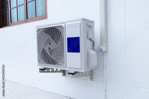 Side of structure old white big air conditioner compressor source heat pumps attached to white wall building. Cooling pump technology home or office. For on roof top of building industrial plant.