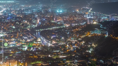 Wallpaper Mural City panorama with Rike Park at night from above. Modern urban park in the old town of Tbilisi aerial timelapse. Illuminated Bridge of Peace and air balloon with historic and modern buildings. Georgia Torontodigital.ca