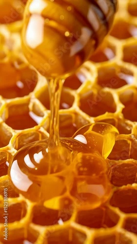 Golden Honey dripping from a wooden dipper onto a honeycomb, creating a glistening, sweet, and viscous substance perfect for breakfast and culinary applications.
