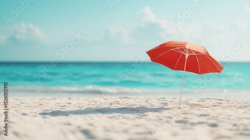 summer concept. Beach scene with a red umbrella and turquoise water in the background.