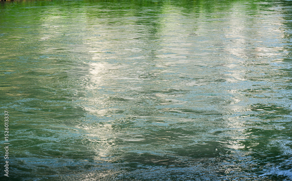 Fototapeta premium Reflections in flowing river water.