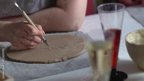 Cropped woman's hands prepare a clay blank. Creative handicraft production of tableware
