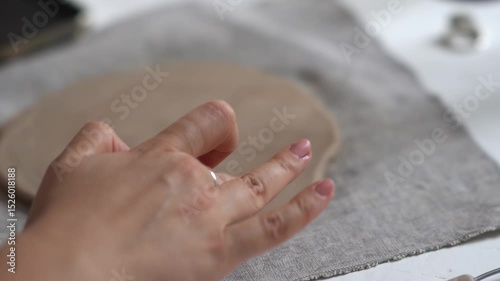 Cropped woman's hands prepare a clay blank. Creative handicraft production of tableware