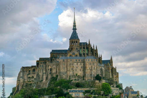 Historic Mont Saint Michel stands majestically against a cloudy sky in France during late afternoon light