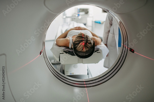 Patient positioned for head scan with laser alignment in CT scanner photo