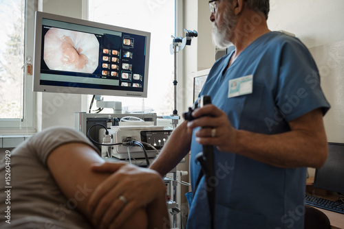 Konstfotografi Doctor looking at monitior during gastroscopy procedure, examining upper digestive tract
