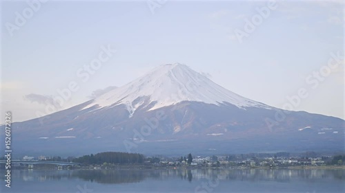 Timelapse of morning over Mount Fuji, illuminating the snow-capped peak and surrounding landscape. Kawaguchiko Lake, Japan