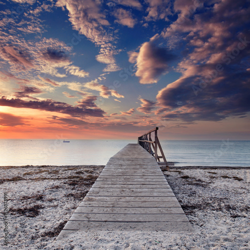 amazing sky over wooden weathered pier at the Baltic Sea beach