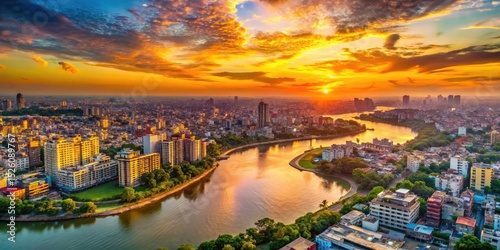 Dhaka's vibrant cityscape ablaze in sunset's golden hues, a river winding through densely packed buildings.