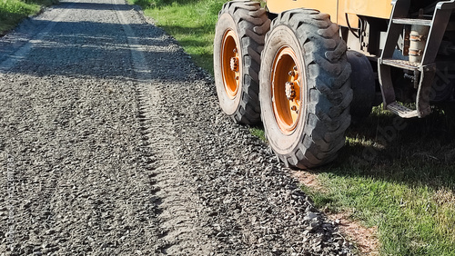 Road Construction. Grader grading gravel for road. New road under construction